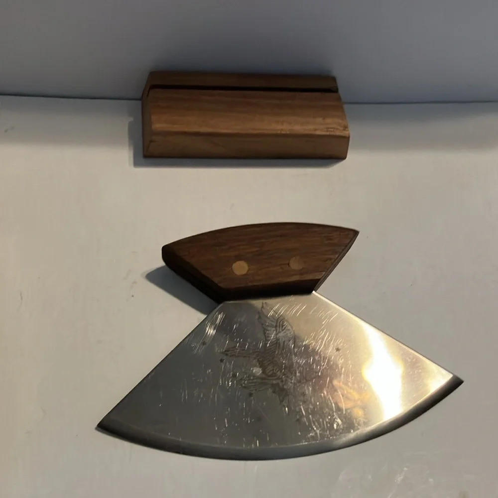 Alaskan Ulu knife with a walnut wood handle and a stand.‎